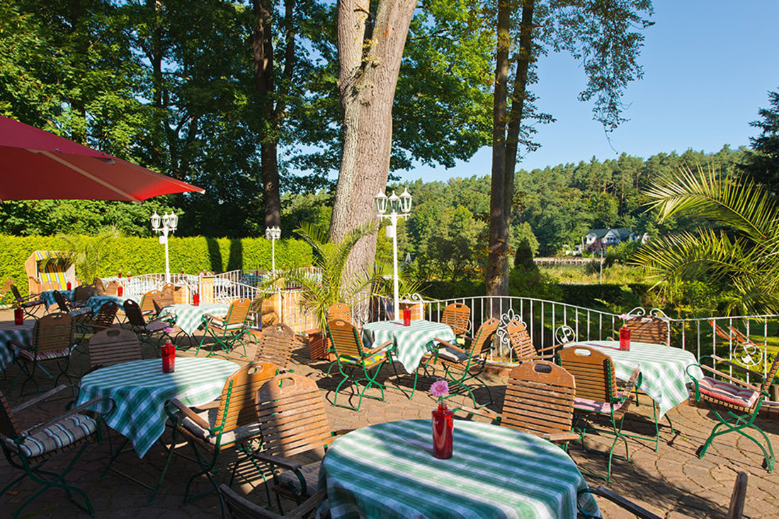 Sommerterrasse des Seeschloss Lanke mit gedeckten Tischen im Sonnenschein